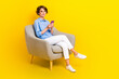 © deagreez - Full length photo of good mood lady wear blue shirt typing modern device empty space isolated yellow color background