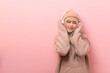© tonefotografia - Portrait of Caucasian young woman wearing sweater using headphones  over pink  background