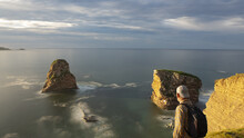 Senior Man Hiking By The Twin Crags Of Hendaye At Sunset, France