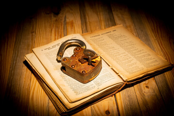 Wall Mural - vintage padlock and book on dark table top view - knowledge is power theme