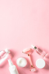 Fototapete - Skin care product, cream, soap serum, jade roller. Natural cosmetics on pink. Flat lay image with copy space.