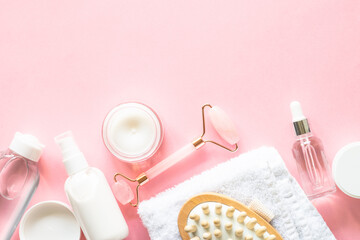 Wall Mural - natural cosmetics on pink. skin care product, cream, soap serum, jade roller and white towel. flat l