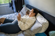 Smiling woman looking at mobile phone while laying on the bed