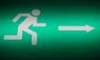 Grünes Schild mit Licht und Zeichen von weißem laufendem Männchen vor weißem Richtungspfeil