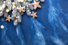 Frame From Branches Fur Tree And Festive  Golden Stars On Deep Blue Murmur Background. Simple Christmas Composition. Top View. Place For  Text..