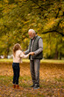 © BGStock72 - Grandfather spending time with his granddaughter in park on autumn day