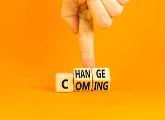 Change is coming symbol. Concept words Change and Coming on wooden cubes. Beautiful orange table orange background. Businessman hand. Business change is coming concept. Copy space.