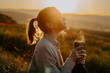 © Cristina - Silhouette of a woman enjoying hot cup of tea on hill at sunset