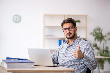 Young male employee sitting in the office