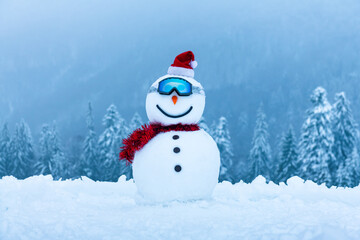 Wall Mural - Funny snowman in ski glass in snowy mountains. Ski resort concept. Merry Christmass and happy New Year