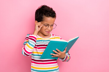 Canvas Print - Photo of smart cute positive schoolboy wavy hairdo wear striped long sleeve read book arm touch glasses isolated on pink color background