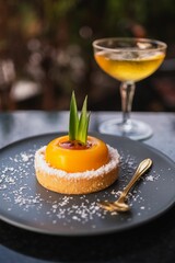 Wall Mural - Fruit dessert served at sunset next to a glass of champagne on a black plate