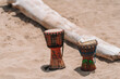 Imagen horizontal de dos pequeños tambores en la arena a la orilla de la playa en un día soleado