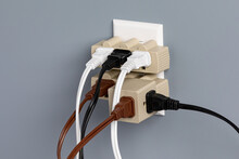 Electrical outlet overloaded with extension cords and adapters. Electricity safety, fire hazard and circuit overload concept