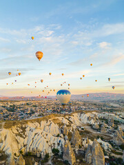 Wall Mural - Breathtaking drone view of hundreds of hot air balloons ride over Turkey's iconic Cappadocia, the underground cities and fairy chimneys valley, rock formations, during the sunrise. High quality photo