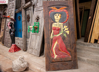 Wall Mural - Skeleton statue with sombrero with wooden doors in the background