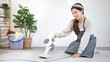 © Puwasit Inyavileart - Beautiful woman vacuuming the floor and pillow of her living room, Big cleaning in the house, Removes germs and dirt and deep stains, Housewife cleaning, Keeping her home clean, Domestic hygiene.