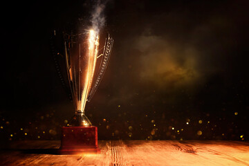 Wall Mural - image of gold trophy with sparkly overlay over dark background