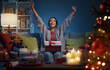 © StockPhotoPro - Cheerful woman opening Christmas gifts