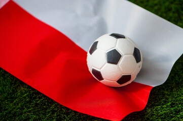 Wall Mural - Poland national football team. National Flag on green grass and soccer ball. Football wallpaper for Championship and Tournament in 2022. World international match.