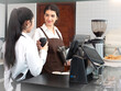 © Nassorn - Young barista and waitress women standing at cafeteria counter bar preparing cappuccino in take away coffee cup for delivery. Two lesbian women couple manage cafe business together. LGBTQ lifestyle.