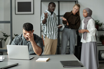 Aufkleber - Middle aged Hispanic businessman sitting by workplace and networking against group of cruel intercultural colleagues bullying him