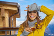 © ZoomTeam - Woman drinking warm tea in the rustic wooden terrace on mountain, alpine view, snow on hills.