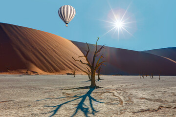 Wall Mural - Hot air balloon flying over Dead trees in Dead Vlei - Sossusvlei, Namib desert, Namibia