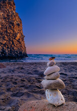 Balance Stone Stack And Big Natural Rock On Sandy Beach At Sunset. 