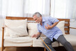 © comzeal - Senior Asian man falling onto couch and holding chest and dropping cane because of a painful heart attack