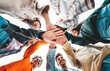 © Davide Angelini - Community of young people stacking hands together - Multiracial college students putting their hands on top of each other - Human relationship, social, community and college concept