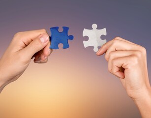 Canvas Print - Human hands hold a puzzle piece for teamwork concept