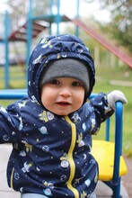 Baby Boy Portrait At Playground In Autumn