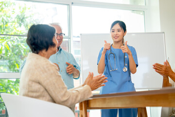 Wall Mural - Pretty Asian nurse or doctor encourage senior man to practice the stretching and relax to get good health in eldery health care clinic by action of thumgs up.