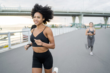 They use comfortable sports clothes. Women and male runners of people do running fitness workout together.