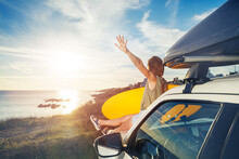 Woman Holding Surfboard Sit On Car Hood Look Over Sunset