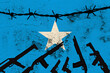 national flag of Somalia on textured background, rows of barbed wire, concept of war, revolution, armed uprising in country, increase in crime in state, terrorist attack, redistribution of power