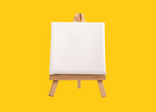White Blank Square Canvas Mock Up, Empty Template With Space On Wood Easel Tripod On Yellow Background