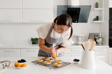 Confectioner Woman Prepares Desserts In The Kitchen. Cooking Delicious Desserts. High Quality Photo