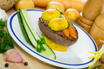 Wall Mural - Juicy beef patty served with baked new potatoes, glazed carrots and fresh greens..