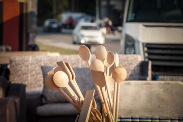 Selective blur on a bunch of kitchen wooden spoons exhibited outdoors; for sale, on a market. These are traditional kitchenware kitchen utensils...