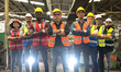 © Jack Tamrong - Photo group of factory workers teamwork standing with armcressed in industrial factory, Engineer Concept