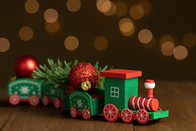 Christmas Toy Train On Wooden Table. Garland Lights In The Background. Shallow Depth Of Field.
