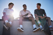 © Irshaad M/peopleimages.com - Diversity, friends and men with skateboard together talking on wall in city. Happy conversation, laughing and gen z skater friendship group with street fashion bonding at skate park outdoors