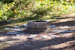 Old stone fire pit outside in a forest. Cracked fire pit in the woods.