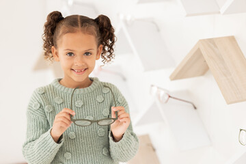 Wall Mural - Girl, child and glasses for vision, shopping and buying spectacles in an optometry store. Retail, choice and eyewear for small kid choosing eyeglasses for eyesight and opthalmology