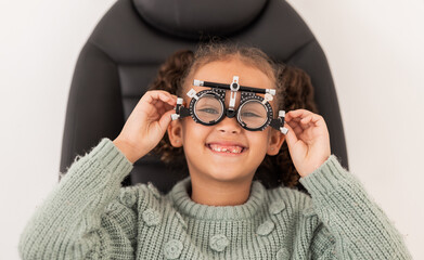 Canvas Print - Vision, eye exam and girl with trial lens for prescription spectacles at optometry shop. Eyewear, eyesight test and happy child trying new optical lenses for optic health, wellness and care in clinic