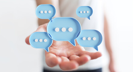 Wall Mural - Businessman using digital speech bubbles talk icons. Minimal conversation or social media messages floating over user hand. 3D rendering