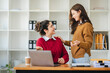 © Daenin - Two diverse female designers smile as they work together at a conference room table during a meeting in a modern office. collaboration concept