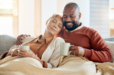 Poster - Black couple relax on sofa with coffee, blanket and smile on winter weekend morning in home. Peace, comfort and love, happy man and tired woman, cozy time on couch with drink in living room together.